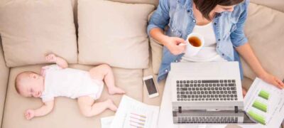 Working mum mit Baby auf dem Sofa